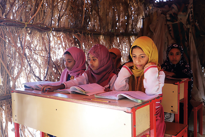 孩子们在也门北部哈杰省一所学校的茅草屋里上课